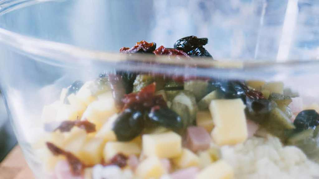 Insalata di riso con pomodori secchi,, olive nere e certriolini