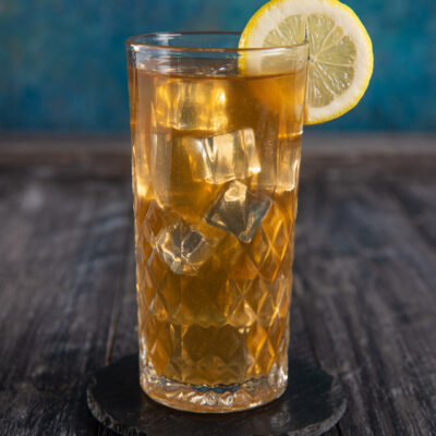 Long Island Ice Tea con cubetti di ghiaccio e fetta di limone sul bordo del bicchiere