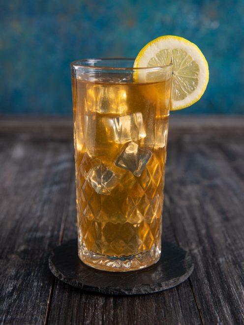 Long Island Ice Tea con cubetti di ghiaccio e fetta di limone sul bordo del bicchiere