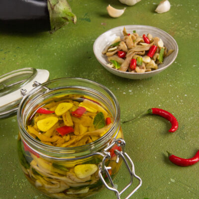 Melanzane sott'olio in barattolo di vetro con peperoncino, aglio e foglie di menta