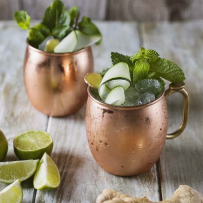 Moscow Mule in tazze di rame con ghiaccio, menta fresca, cetriolo arrotolato e zenzero