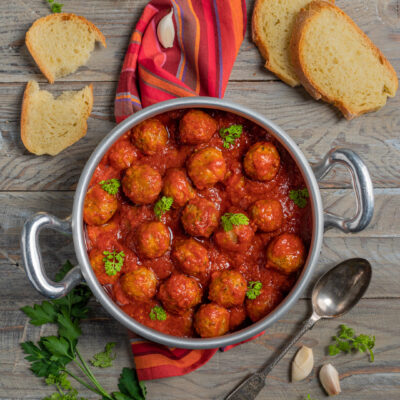 Polpette di carne al sugo di pomodoro con prezzemolo fresco, servite in padella