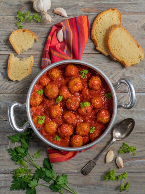 Polpette di carne al sugo di pomodoro con prezzemolo fresco, servite in padella