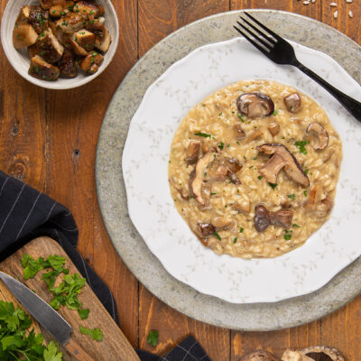 Risotto ai funghi cremoso con fette di funghi saltati e prezzemolo tritato