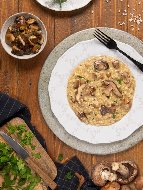 Risotto ai funghi cremoso con fette di funghi saltati e prezzemolo tritato