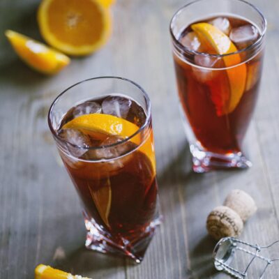 Negroni Sbagliato con ghiaccio e spicchi d'arancia in due bicchieri alti