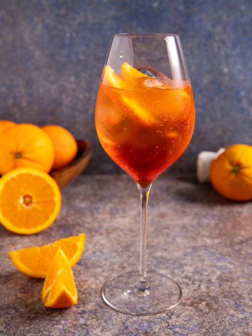 Spritz cocktail con ghiaccio e spicchi d'arancia, servito in calice da vino