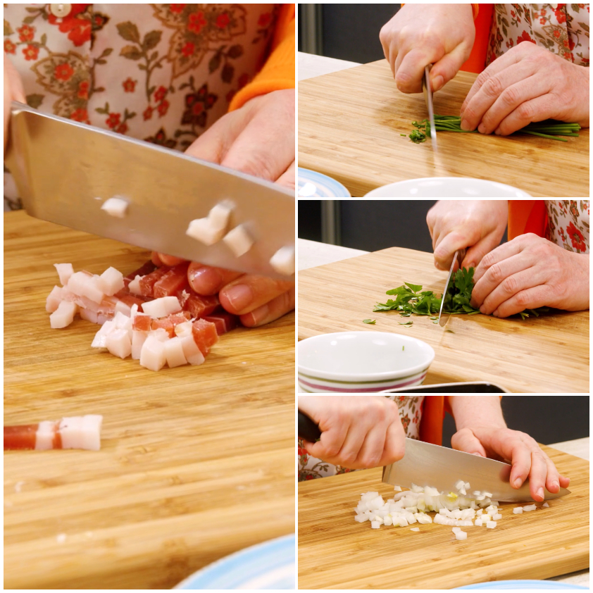 Mani che tagliano speck a cubetti, erba cipollina, prezzemolo e cipolla sul tagliere