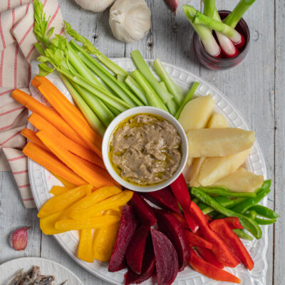 Bagna caoda servita con verdure crude e cotte: carote, sedano, peperoni, barbabietola e patate lesse