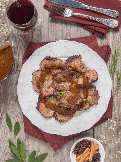 Brasato al Barolo affettato e nappato con salsa scura, guarnito con aghi di rosmarino