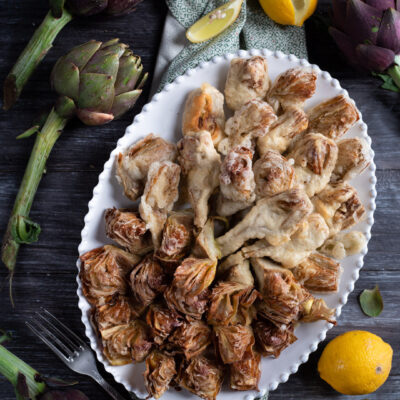 Carciofi fritti croccanti serviti in due versioni: dorati in pastella e fritti secchi con foglie aperte