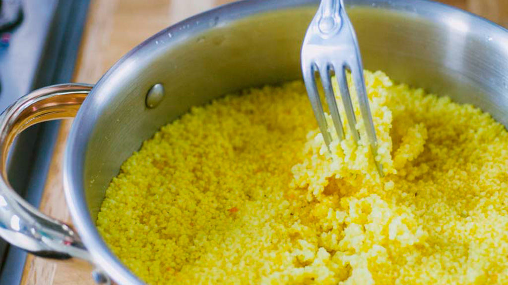 Couscous sgranato con la forchetta, leggero e sabbioso, con verdure al centro del piatto