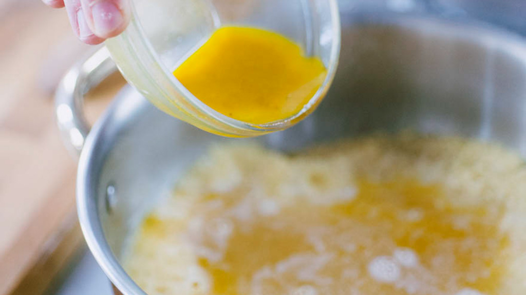 Couscous coperto a riposo mentre assorbe il brodo dorato allo zafferano