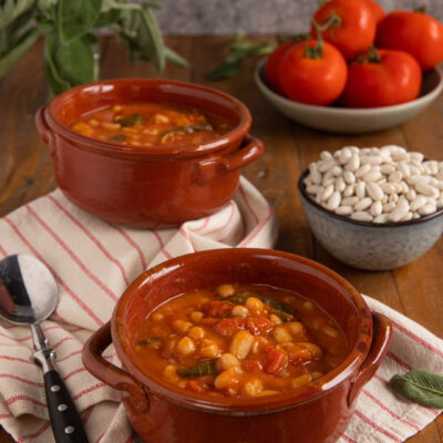 Fagioli all'uccelletto con pomodoro e salvia serviti in ciotole di terracotta