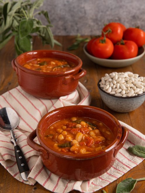 Fagioli all'uccelletto con pomodoro e salvia serviti in ciotole di terracotta