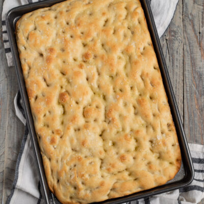 Focaccia appena sfornata con fossette, olio e sale grosso in superficie