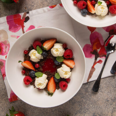 Passione cioccolato e lamponi con rosette di panna, fragole, mirtilli e lamponi su crumble al cacao