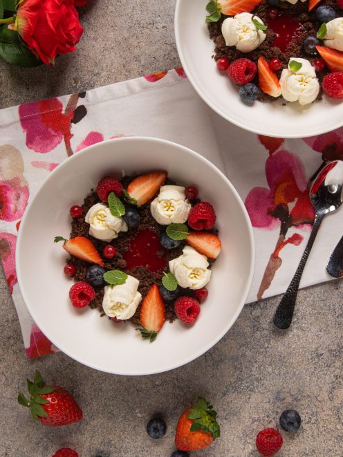 Passione cioccolato e lamponi con rosette di panna, fragole, mirtilli e lamponi su crumble al cacao
