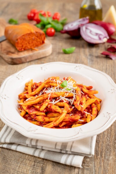 Pasta con la 'nduja e cipolle rosse condita con sugo ricco e parmigiano grattugiato