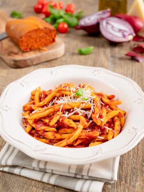 Pasta con la 'nduja e cipolle rosse condita con sugo ricco e parmigiano grattugiato