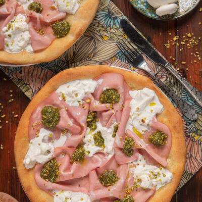 Pizza bianca con mortadella, burrata e pesto di pistacchi servita con granella di pistacchio