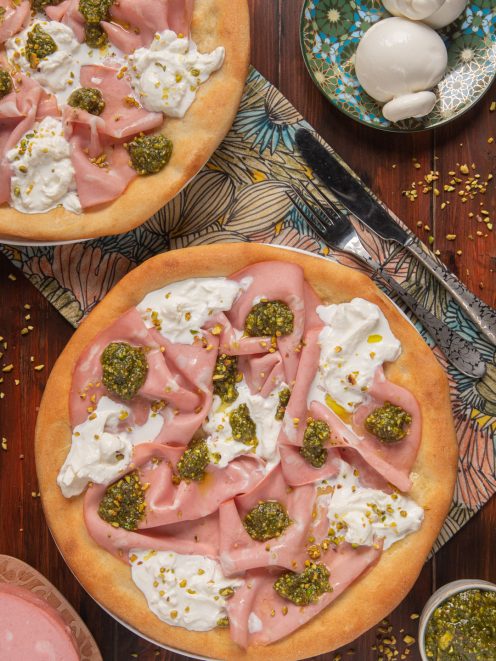 Pizza bianca con mortadella, burrata e pesto di pistacchi servita con granella di pistacchio