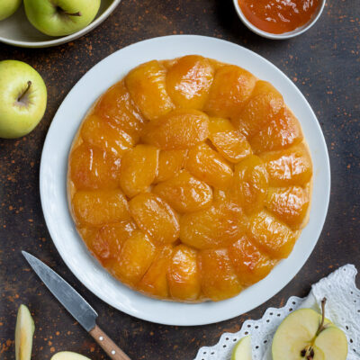 Tarte tatin alle mele con fette di mela caramellate disposte a cerchio e glassa lucida