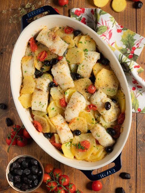 Baccalà e patate al forno con pomodorini, olive nere e prezzemolo tritato