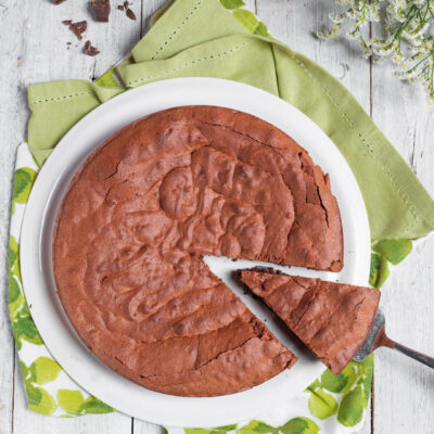 Torta tenerina al cioccolato con una fetta sollevata dalla spatola