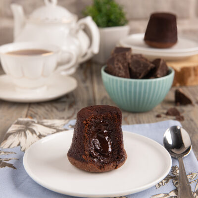 Tortino al cioccolato con cuore fondente tagliato a meta con colata di cioccolato caldo