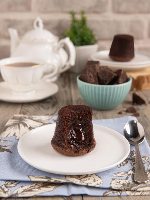 Tortino al cioccolato con cuore fondente tagliato a meta con colata di cioccolato caldo