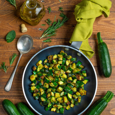 Zucchine in padella saltate a cubetti con erbe aromatiche tritate