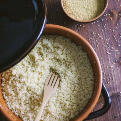 Couscous sgranato con forchetta di legno, pronto da servire