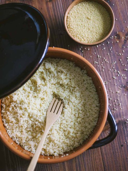 Couscous sgranato con forchetta di legno, pronto da servire