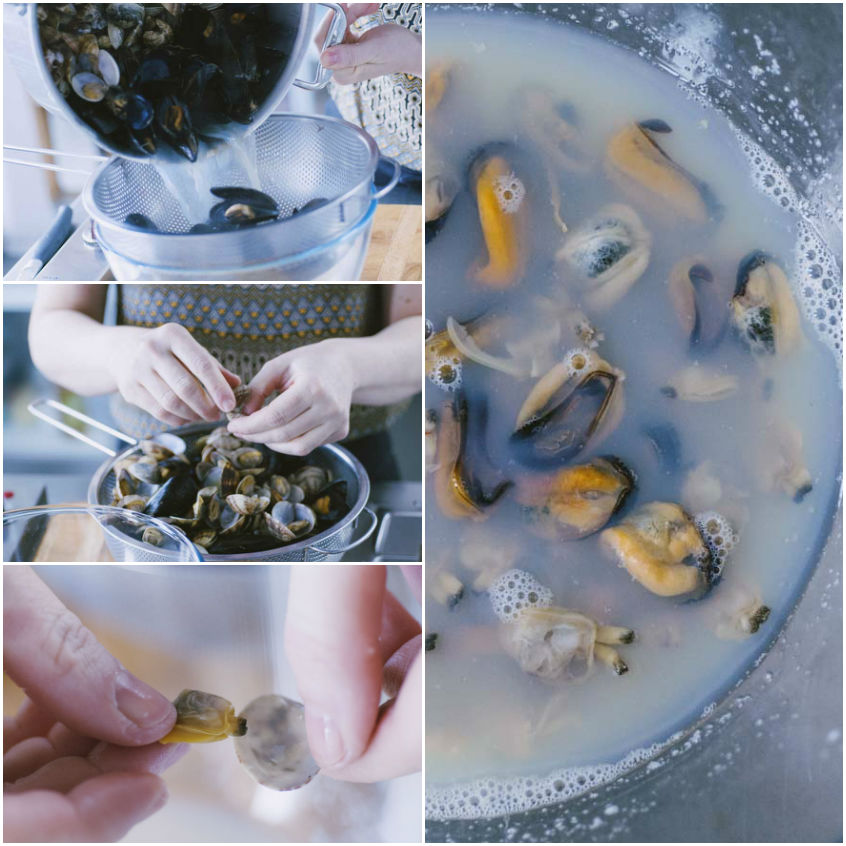 Mani che sgusciano cozze e vongole cotte, immerse nel loro liquido di cottura schiumoso
