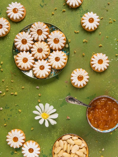 Biscotti margherita a forma di fiore con zucchero a velo e marmellata di albicocche al centro
