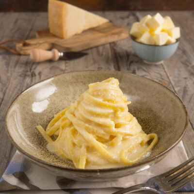 Fettuccine Alfredo avvolte in crema di burro e parmigiano, servite a nido alto