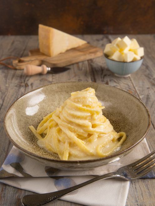 Fettuccine Alfredo avvolte in crema di burro e parmigiano, servite a nido alto