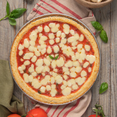 Finta pizza di cavolfiore con salsa di pomodoro, mozzarella fusa e foglie di basilico