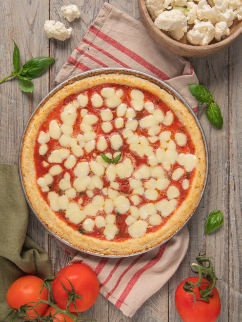 Finta pizza di cavolfiore con salsa di pomodoro, mozzarella fusa e foglie di basilico