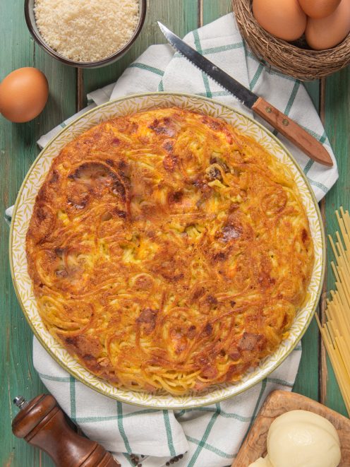 Frittata di spaghetti dorata e croccante in superficie, con uova e formaggio grattugiato
