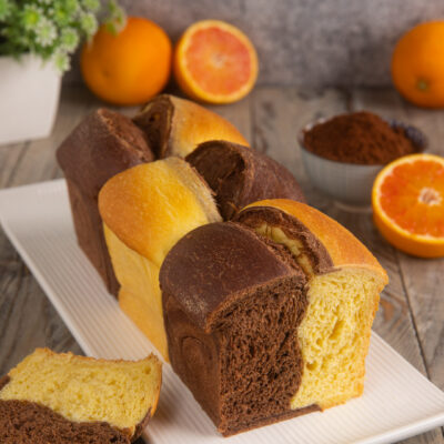 Pan brioche bicolore al cacao e arancia tagliato a fette con mollica soffice a due colori