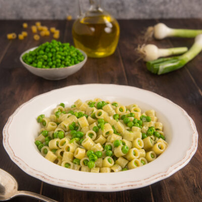 Pasta e piselli con ditalini e piselli verdi condita con olio