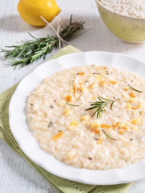 Risotto al limone e rosmarino con provola a cubetti e un rametto fresco in superficie