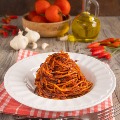 Spaghetti all'assassina con salsa di pomodoro ben tostata, impiattati a nido alto