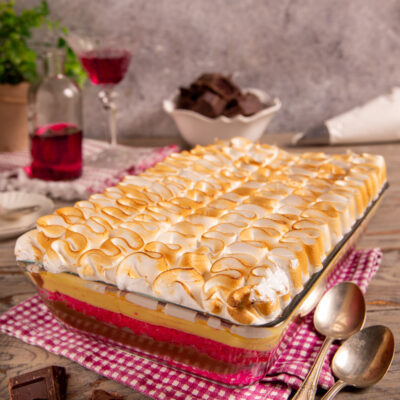 Zuppa inglese a strati con crema pasticcera e meringa dorata gratinata in superficie