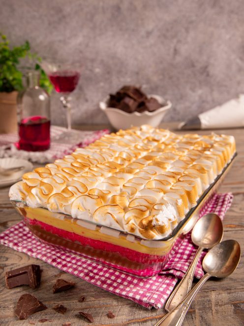 Zuppa inglese a strati con crema pasticcera e meringa dorata gratinata in superficie