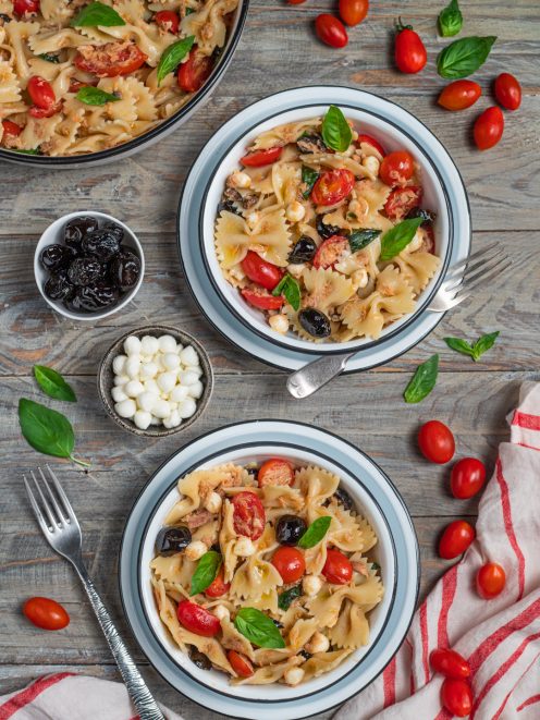 Insalata di pasta con farfalle, tonno, pomodorini, olive nere, mozzarella e basilico fresco