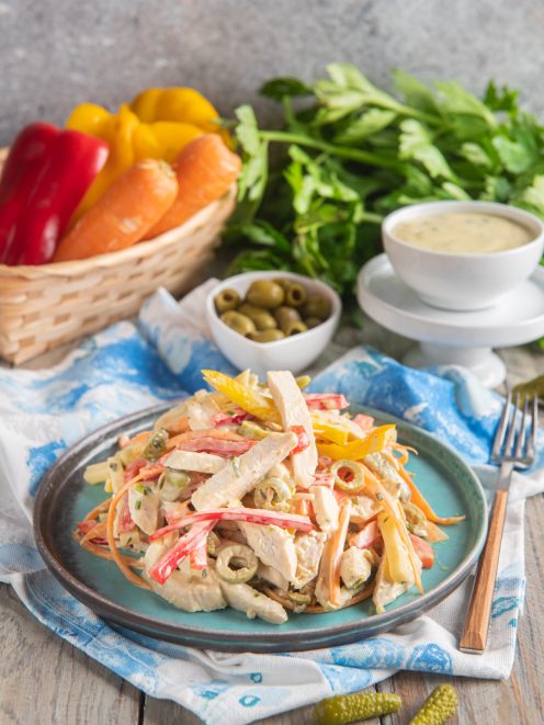 Insalata di pollo con strisce di peperone, carote julienne, olive verdi e salsa cremosa