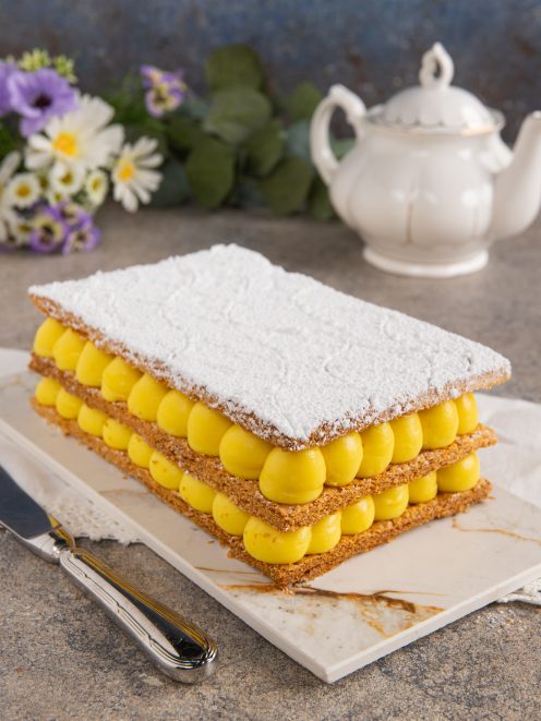 Millefoglie a strati con crema pasticciera a cupolette e zucchero a velo in superficie